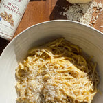 A delicious bowl of pasta sitting next to a bottle of La Tourangelle White Truffle Oil.