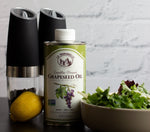 Expeller-pressed grapeseed oil from La Tourangelle next to a green salad, lemon and black pepper