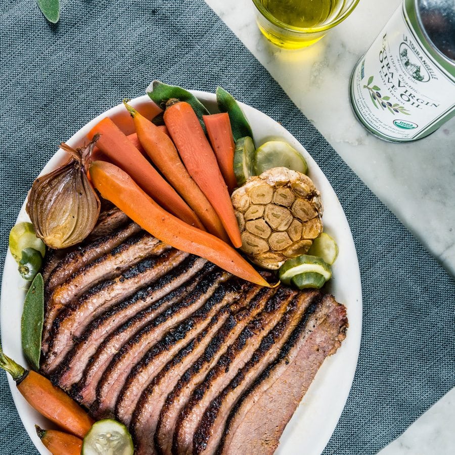 Brisket on plate with carrots and other vegetables.