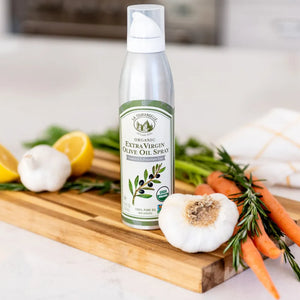 
                  
                    Organic Bright & Peppery Extra Virgin Olive Oil spray next to garlic
                  
                